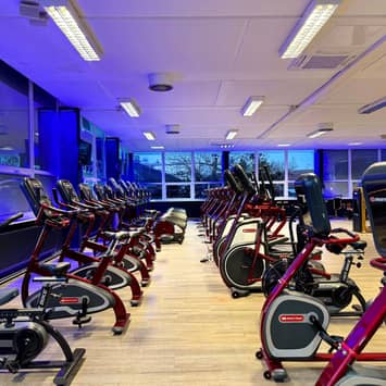 Cardio-Zone mit mehreren Reihen von Ergometern Reihen von Ergometern im Fitnessstudio