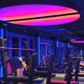 Futuristischer Trainingsraum mit professionellen Fitnessgeräten Modernes Fitnessstudio mit Neonlicht