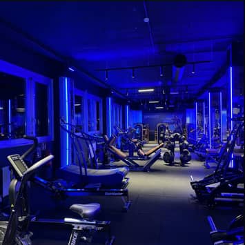 Moderner Fitnessbereich mit blauem Licht Beleuchteter Trainingsraum