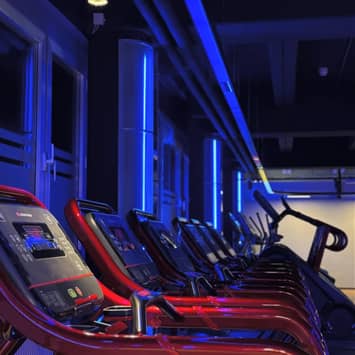 Beleuchtete Cardio-Zone mit modernen Laufbändern Laufbänder im Fitnessstudio