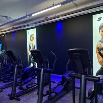 Cardio-Reihe vor Motivationspostern Laufbänder an der Wand