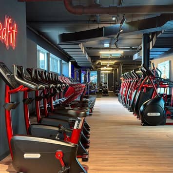 Langer Cardio-Korridor mit roter Gerätelinie Cardiogeräte im Gang