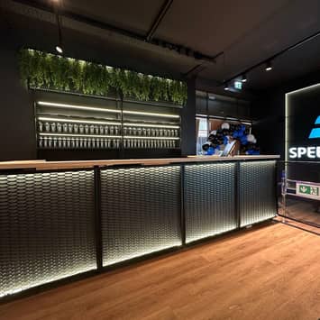 Beleuchteter Servicebereich im Studio Empfangstheke mit Logo