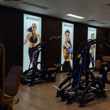 Trainingsbereich vor Motivationspostern Maschinenreihe an der Wand