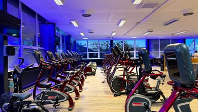 Cardio-Zone mit mehreren Reihen von Ergometern Reihen von Ergometern im Fitnessstudio