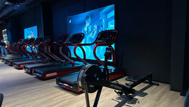 Cardio-Bereich mit Trainingsgeräten vor Bildschirm Cardiogeräte vor Bildschirm
