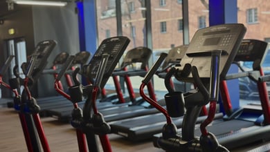 Heller Cardio-Bereich mit Blick nach draußen Cardiogeräte am Fenster im Fitnessstudio