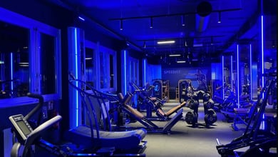 Moderner Fitnessbereich mit blauem Licht Beleuchteter Trainingsraum