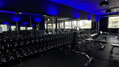Hanteltraining in ruhiger Studioatmosphäre Freihantelraum mit Spiegeln