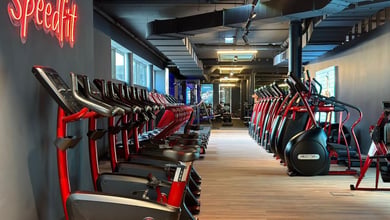 Langer Cardio-Korridor mit roter Gerätelinie Cardiogeräte im Gang