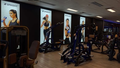 Trainingsbereich vor Motivationspostern Maschinenreihe an der Wand